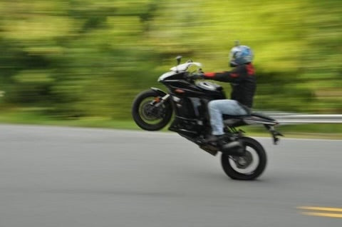 Tony Wyatt today, popping a wheelie on a motorcycle — still riding decades after the 1983 wreck that started it all.